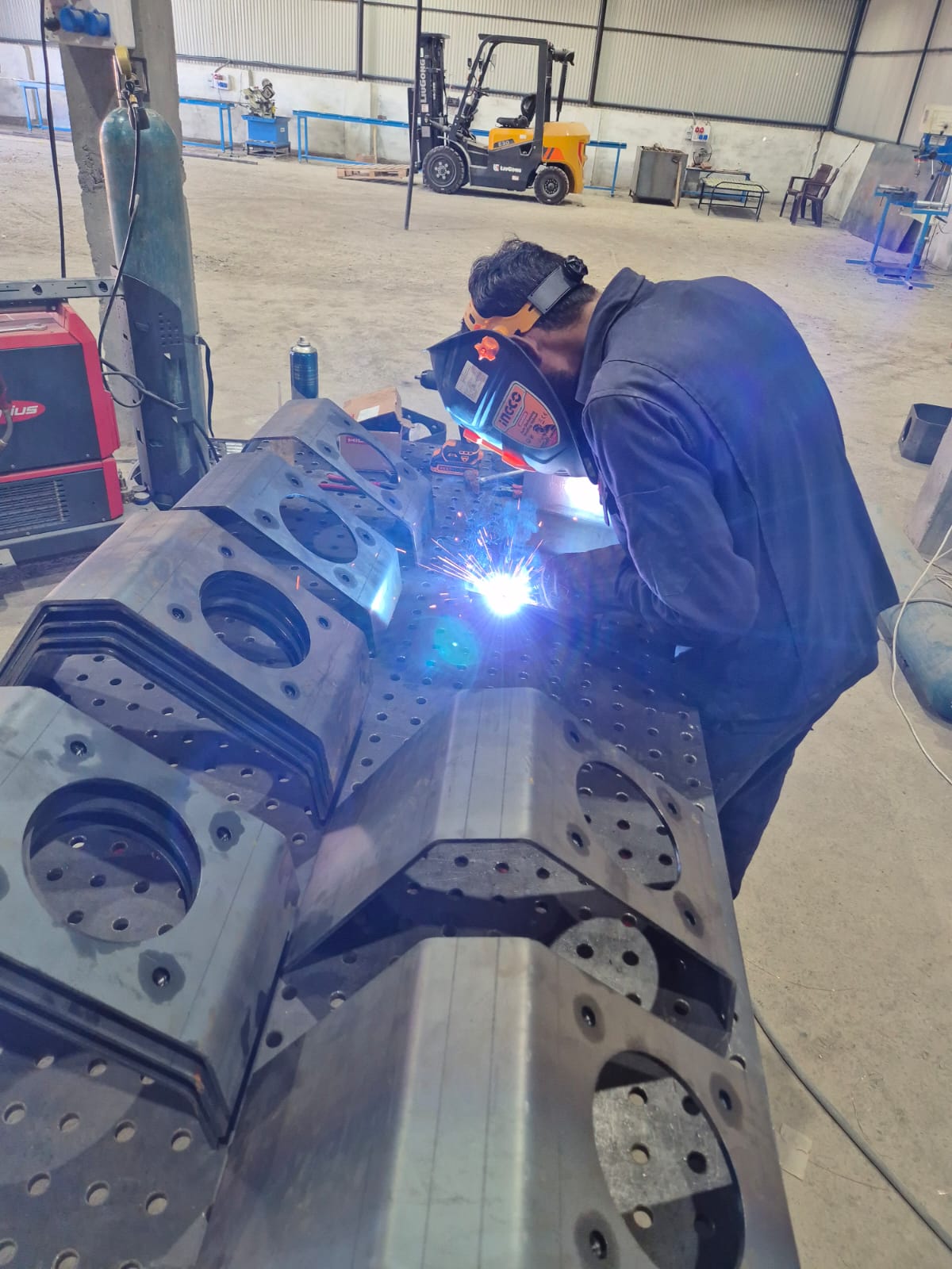 Managing Director Thomas Gaus welding on Cyclotron fixture table
